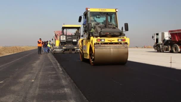 Rodillos de carretera nivelando pavimento de asfalto fresco — Vídeos de Stock