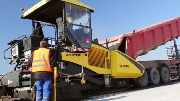 Bijgehouden bestratingsafwerkmachines houdende van verse asfalt bestrating — Stockvideo