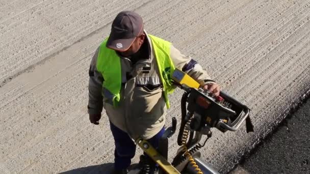 Trabajador de la construcción operando máquina pavimentadora rastreada — Vídeos de Stock