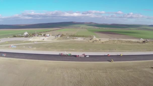 Tracked paver meletakkan aspal segar di landasan pacu bandara, pandangan udara — Stok Video