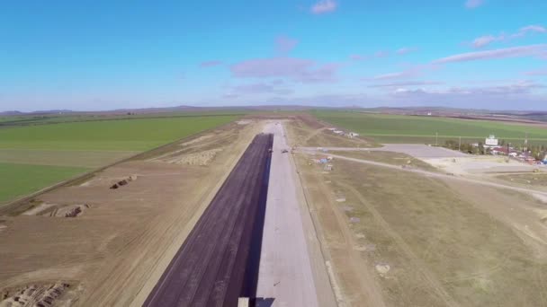 Paver rastreado que estabelece pavimento asfáltico fresco em uma pista do aeroporto, vista aérea — Vídeo de Stock