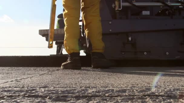 Bijgehouden bestratingsafwerkmachines houdende van verse asfalt bestrating — Stockvideo