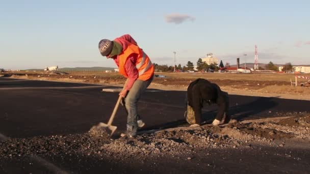 Los trabajadores cavan trincheras para tender cables para el sistema de iluminación del aeródromo — Vídeos de Stock