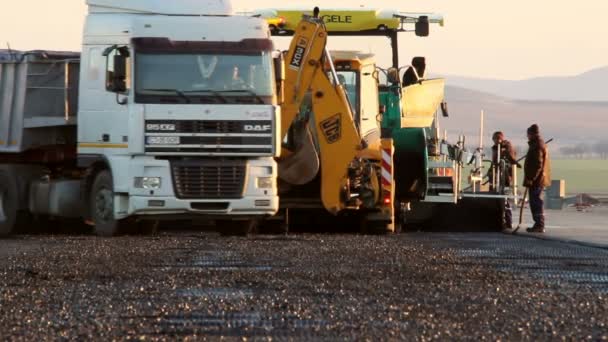 Bijgehouden bestratingsafwerkmachines houdende van verse asfalt bestrating — Stockvideo