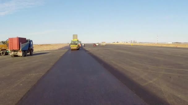 Bijgehouden bestratingsafwerkmachines houdende van verse asfalt stoep, luchtfoto — Stockvideo