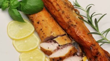 Füme sazan aromatik otlar ve beyaz tabakta limon ile döner