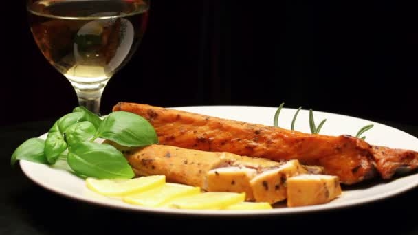 Smoked carp with aromatic herbs and lemon on white plate, rotating — Stock Video