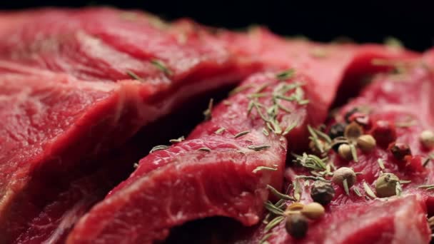 Νωπό ωμό κρέας βοδινού με κόκκους πιπεριού έτοιμο για ψήσιμο, περιστρεφόμενο — Αρχείο Βίντεο