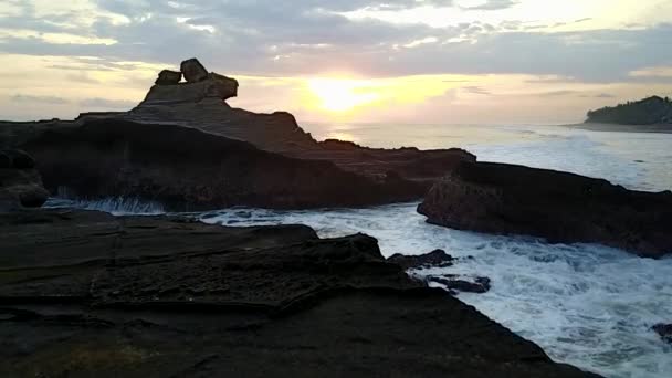 海に沈む夕日。岩の眺め、大きな波 — ストック動画