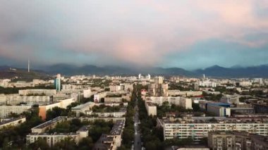 Almaty şehrinin üzerinde parlak renkli günbatımı.