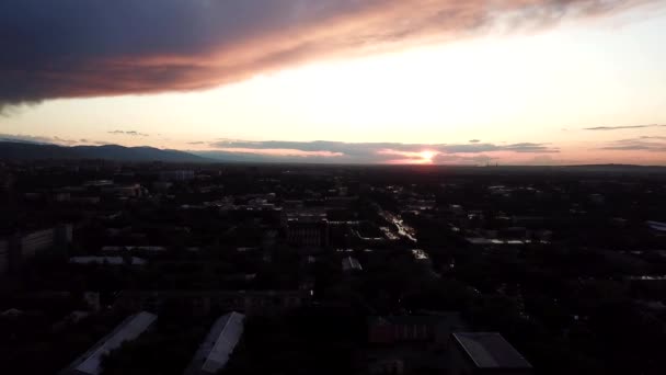 Rode zonsondergang met wolken boven de stad Almaty. — Stockvideo