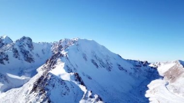 Karla kaplı yüksek kayalar. Tuyuk Su Buzulu