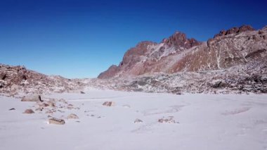 Karla kaplı yüksek kayalar. Tuyuk Su Buzulu