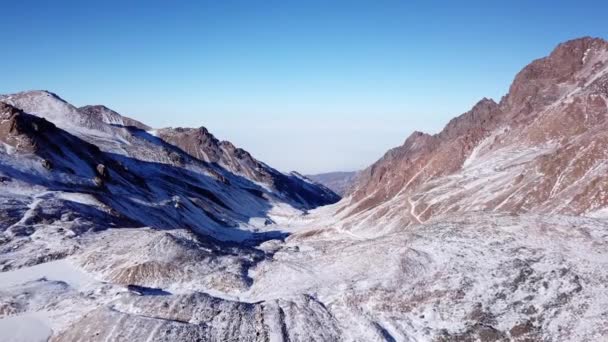 Rocas altas cubiertas de nieve. El glaciar Tuyuk Su — Vídeos de Stock