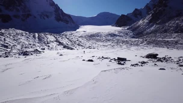 Bir dağcı karlı dağların arasında yürüyor.. — Stok video