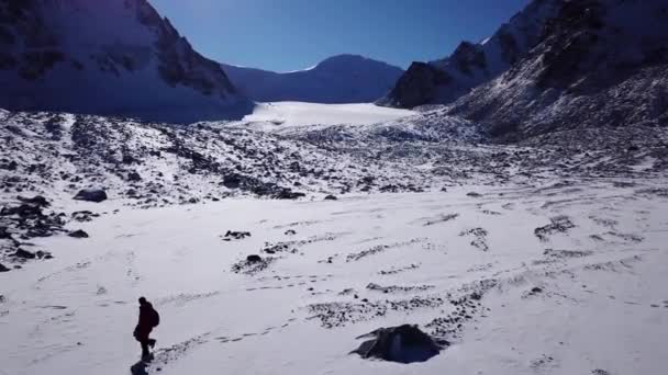 Bir dağcı karlı dağların arasında yürüyor.. — Stok video