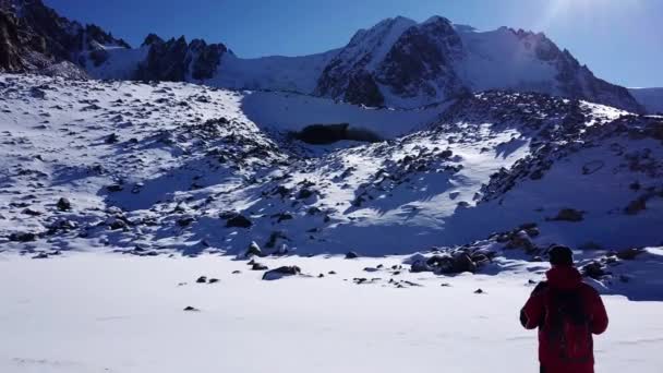 氷の洞窟の入り口を見る登山家. — ストック動画