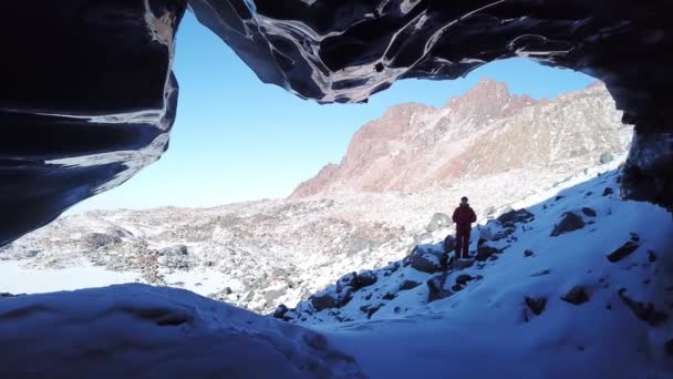 その男は氷の洞窟を探検する。危険な場所だ. — ストック動画