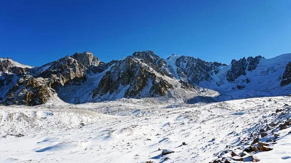 Alte rocce coperte di neve. Il ghiacciaio Tuyuk Su — Foto Stock