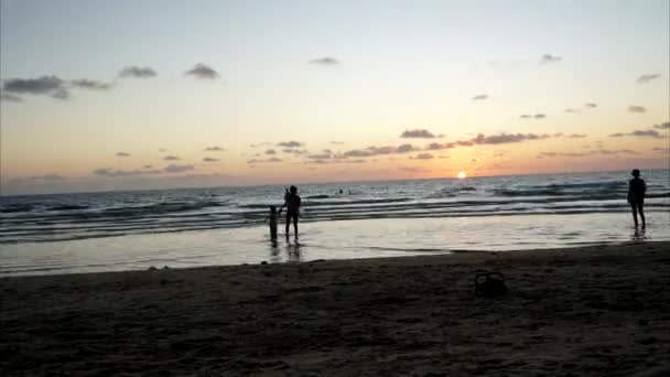 Ηλιοβασίλεμα στην παραλία. Ο κόσμος ξεκουράζεται.. — Αρχείο Βίντεο