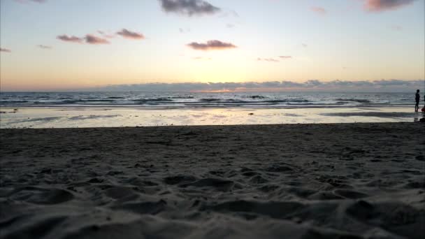Zonsondergang timelapse op het strand. Mensen rusten uit.. — Stockvideo