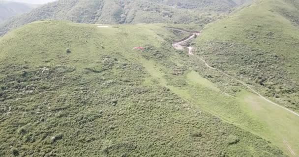 Paragliding v horách. Zelená pole, kopce. — Stock video