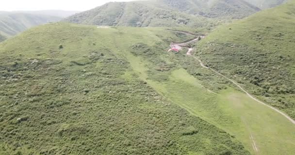 Dağlarda paraşütle atlamak. Yeşil tarlalar, tepeler. — Stok video