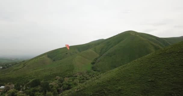 Paragliden in de bergen. Groene velden, heuvels. — Stockvideo