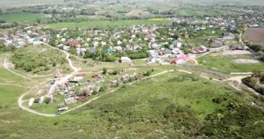 Dağlarda paraşütle atlamak. Yeşil tarlalar, tepeler.