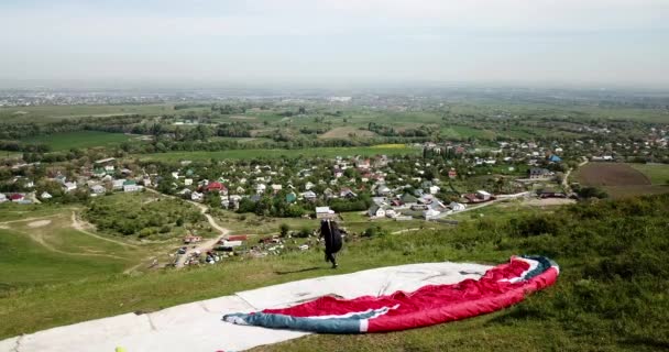 Paragliden in de bergen. Groene velden, heuvels. — Stockvideo