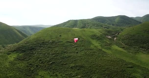 Paralotniarstwo w górach. Zielone pola, wzgórza. — Wideo stockowe