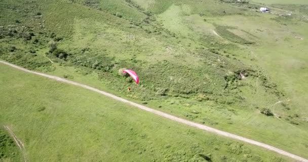 Paragliden in de bergen. Groene velden, heuvels. — Stockvideo