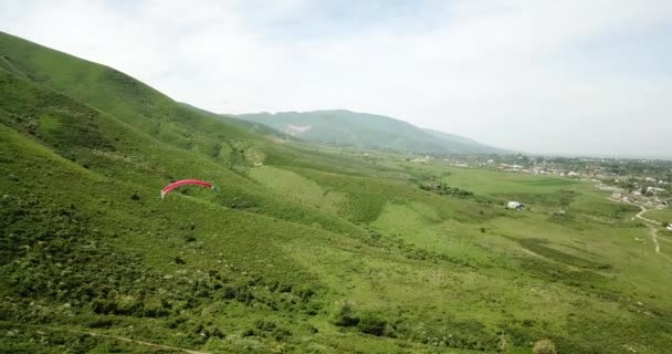 Parapente nas montanhas. Campos verdes, colinas. — Vídeo de Stock