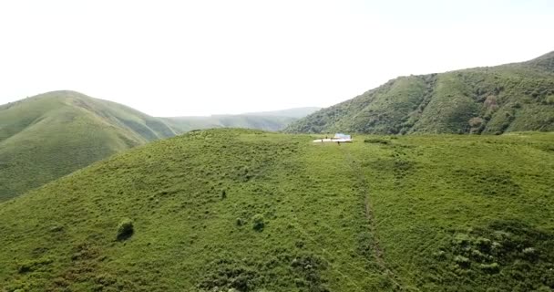 Dağlarda paraşütle atlamak. Yeşil tarlalar, tepeler. — Stok video