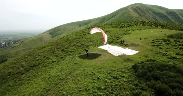 Paragliding in the mountains. Green fields, hills. — Stock Video