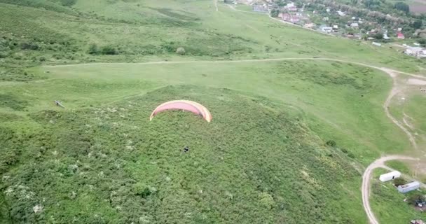 Paragliding in the mountains. Green fields, hills. — Stock Video