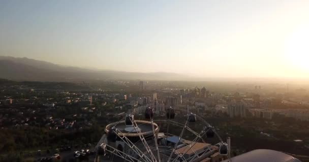 Grande roue sur la colline verte Kok Tobe au coucher du soleil — Video