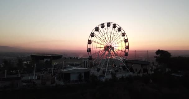 Roda gigante na colina verde Kok Tobe ao pôr-do-sol — Vídeo de Stock