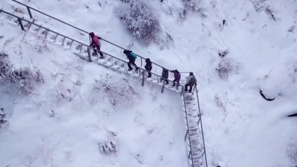 Группа людей поднимается по железной лестнице в горах — стоковое видео