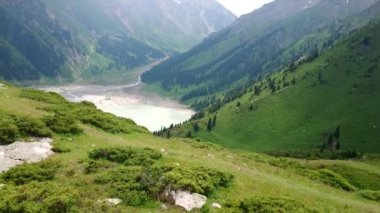 Dağlardaki büyük Almaty Gölü. Yeşil tepe.