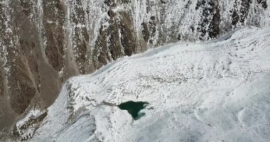 Buzlu göl, kayaların ve karların arasındaki vadide.