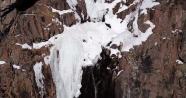 Karlı dağlarda donan şelale.