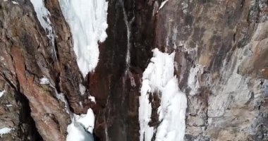 Karlı dağlarda donan şelale.