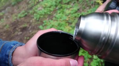 Kadınların elleri bardağı tutar ve çay döker..