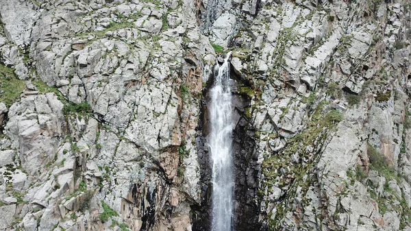 Högt vattenfall bland klipporna. Utsikt från en drönare. — Stockfoto