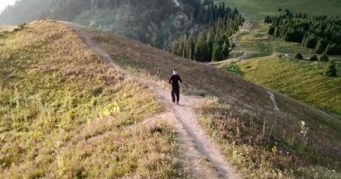 Dağlarda şafak ve tepede bir adam.