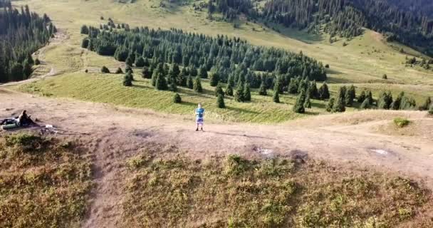 Aube dans les montagnes et un gars sur une colline. — Video