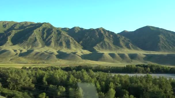 Uitzicht vanuit het autoraam naar de groene heuvels. — Stockvideo