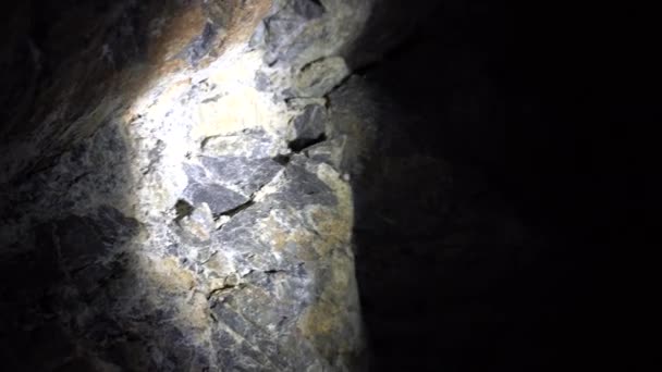 Luz de una linterna en la pared de la cueva. — Vídeo de stock