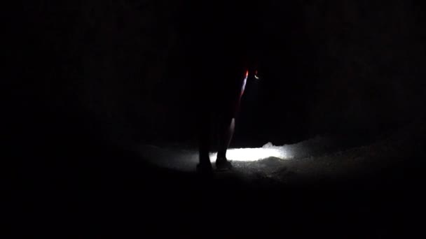 Um tipo com uma lanterna numa caverna escura. — Vídeo de Stock